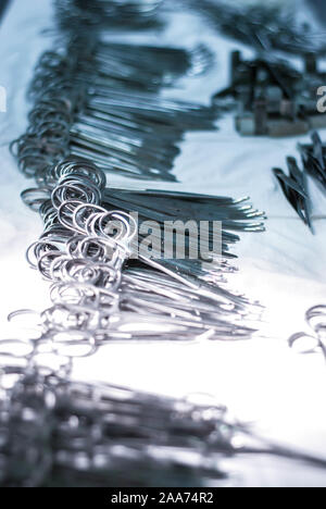 selective focus surgical instrument lying on table while group of surgeon work in operation room at hospital, emergency case, surgery, medical technol Stock Photo