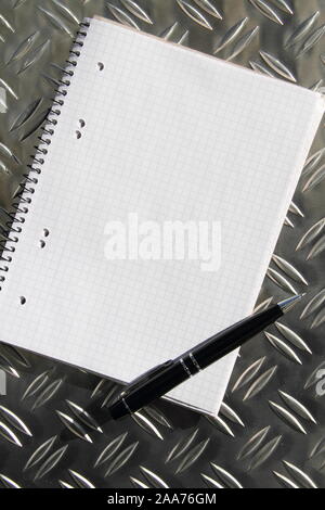 empty writing pad with pen on a table Stock Photo