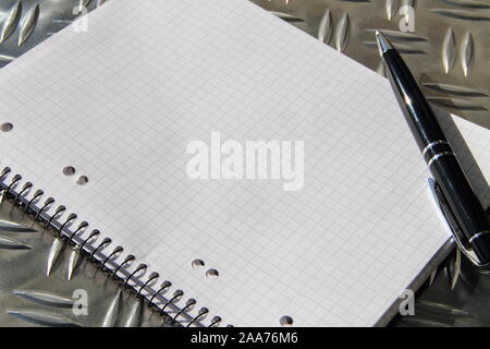 empty writing pad with pen on a table Stock Photo
