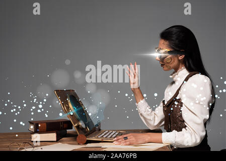 Steampunk Woman In Goggles Waving Hand During Video Chat With Glowing Digital Illustration Isolated On Grey Stock Photo Alamy