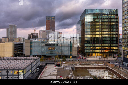 London, England, UK - November 11, 2019: Dusk falls on Westfield Shopping Centre and the modern new build office blocks and high rise apartment buildi