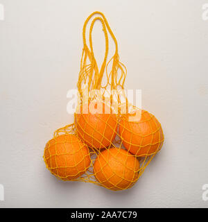 Oranges in a mesh string bag made of natural material. Environmental protection Stock Photo