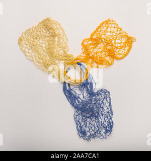 Concept of the three colored bags made from natural materials on a light background. Environmental protection Stock Photo
