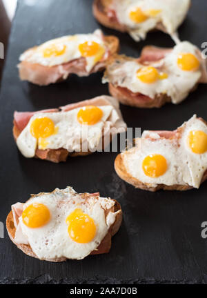 Bruschettas with Fried Quail Eggs and jamon Stock Photo