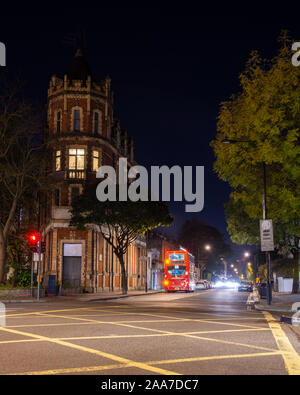London, England, UK - November 7, 2019: A double-decker London Bus and other traffic moves along Westbourne Grove in the Notting Hill neighbourhood of Stock Photo