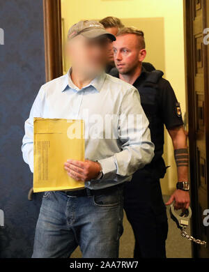 Schwerin, Germany. 20th Nov, 2019. The defendant, a former member of a police special task force (SEK), is brought into the courtroom by other police officers. In the trial in connection with the right-wing Prepper group 'Nordkreuz', the 49-year-old accused is accused of illegally stockpiling weapons and thus of violating the Weapons Act, the War Weapons Control Act and the Explosives Act. Preppers are people who prepare for the collapse of our civilization through political upheavals, wars or natural disasters (English: to prepare). Credit: Bernd Wüstneck/dpa-Zentralbil/dpa/Alamy Live News Stock Photo