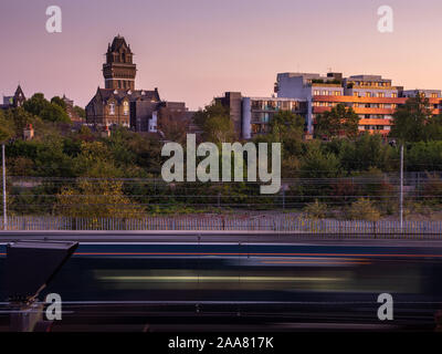 London, England, UK - September 17, 2019: A Great Western Railway train passes Ladbroke Grove at sunset, with St Charles Hospital and housing of North Stock Photo