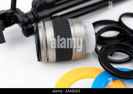 Photo camera lens close-up, with lens protectors and small tripod on white background Stock Photo