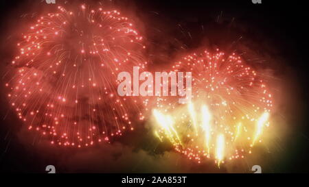Festive bright fireworks in the night sky. Shining lights and celebration show Stock Photo