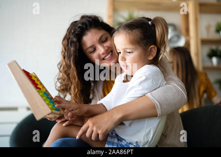 Happy loving family. Beautiful mother and child girl playing, kissing and hugging Stock Photo