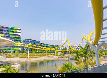 Gold Coast Australia - November 19 2019; Yellow wave-like architectural feature around pond with modern green and blue designed apartment buildings1 Stock Photo