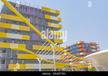 Gold Coast Australia - November 19 2019; Yellow wave-like architectural feature in foreground of modern yellow and orange colored and  designed apartm Stock Photo