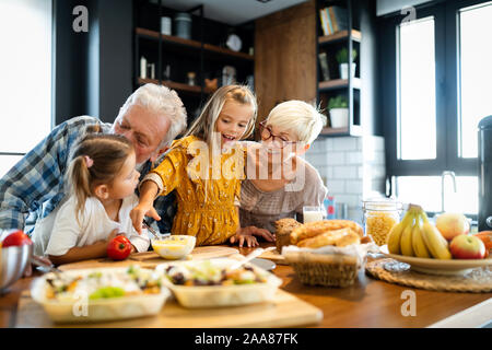 Happy grandchildrens girls having breakfast with her grandparents Stock Photo