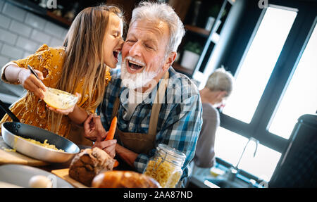 Grandfather and his grandchildren spendig happy fun time in kitchen Stock Photo