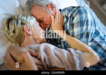 Lovely senior couple lying, sleeping on bed together Stock Photo
