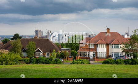 London, England, UK - July 7, 2019: The Wembley Stadium Arch and high rise new buildings appear over the suburban houses of Barn Hill in London. Stock Photo