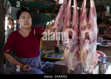 The lively meat,fish,vegetable & fruit market of Pakokku, Myanmar (Burma) with a young woman selling freshly butchered meat Stock Photo