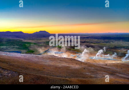Iceland. Steam rises above the hot springs at sunset. Thermal springs. Renewable energy. Stock Photo