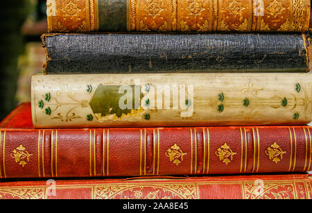 Five very old antiquarian books stacked on side in leather covers. Stock Photo