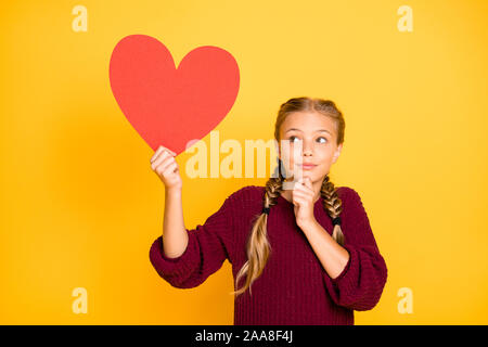 Portrait of her she nice attractive charming lovely curious confused pre-teen girl thinking holding in hand big heart isolated over bright vivid shine Stock Photo