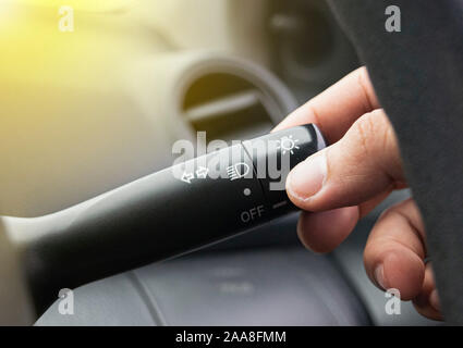Hand adjusting car headlight control switch Stock Photo