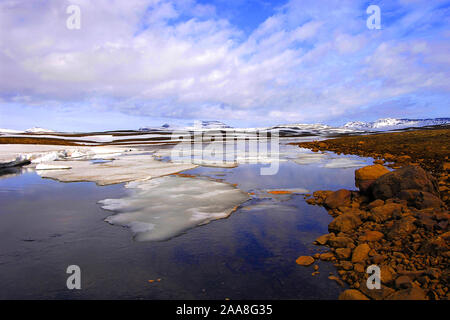 Spring melt in the Miohusaa river above the town of Egilstadir, with a distant view of the Fjardarheidi mountains, east Iceland Stock Photo