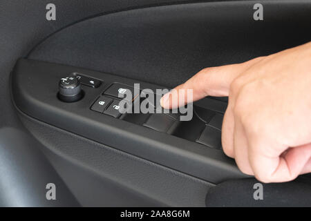 Closeup photo of man pressing button controlling window in car Stock Photo