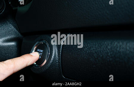 Car start stop system with finger pressing the button, horizontal image Stock Photo