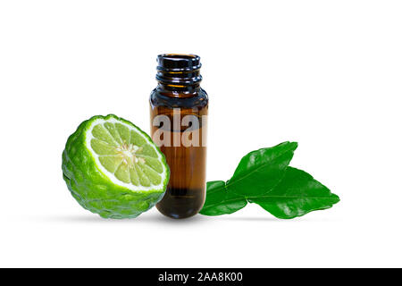 Bottle of essential oil and fresh kaffir lime or bergamot fruit with leaves isolated on white background Stock Photo