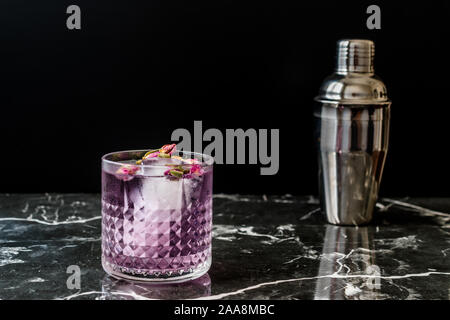 https://l450v.alamy.com/450v/2aa8mbc/pink-gin-tonic-cocktail-with-dried-rose-buds-and-ice-in-glass-cup-ready-to-drink-2aa8mbc.jpg
