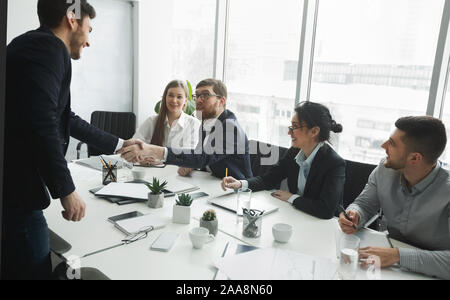 Satisfied HR managers shaking hands with applicant Stock Photo