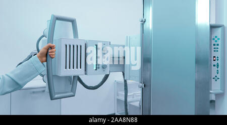 Woman hand holding X-ray machine in modern medical laboratory Stock Photo