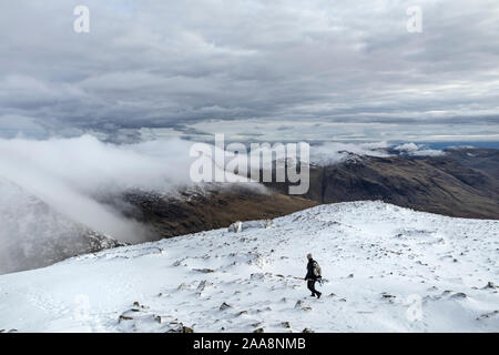Walker on the Summit of Scafell in Winter with the View Southeast over Cloud Covered Crinkle Crags and Beyond Towards the Coniston Fells, Lake, Distri Stock Photo