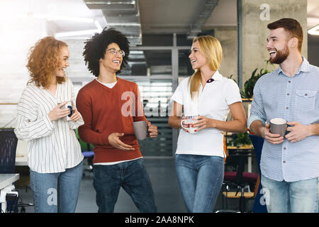 Diverse colleagues enjoying communication in modern office Stock Photo