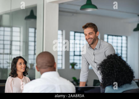 Smiling manager having a meeting with his diverse staff Stock Photo