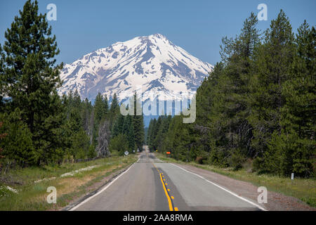 Two lane highway leading to snow covered Mount Shasta in the distance Stock Photo