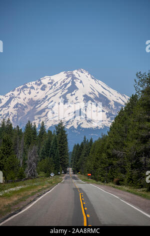 Two lane highway leading to snow covered Mount Shasta in the distance Stock Photo