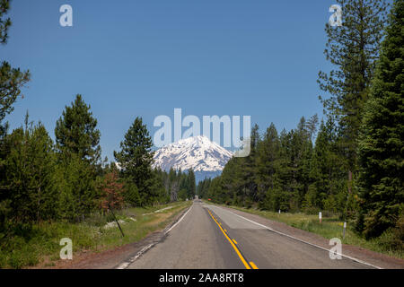 Two lane highway 89 leading to snow capped Mount Shasta in distance Stock Photo