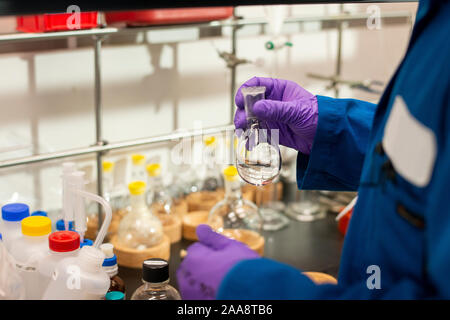 Preparing to add clear liquid from a Florence flask in a lab Stock Photo
