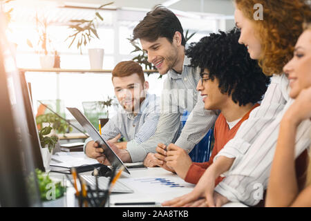 Young team analyzing information on computer screen in office Stock Photo
