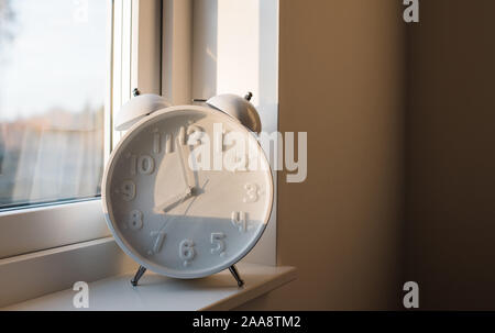 a large alarm clock sat on a window ledge of a home Stock Photo