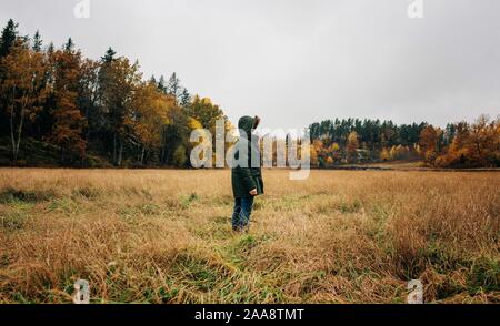 man standing in the middle of a country field looking and thinking Stock Photo