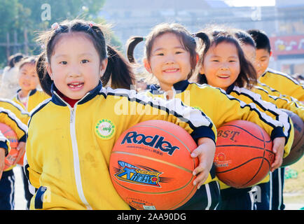 Young Chinese kids have fun with basketballs on the playground to mark the World Children's Day at a kindergarten in Motou Town, Rugao City, east Chin Stock Photo