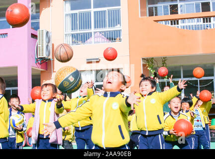 Young Chinese kids have fun with basketballs on the playground to mark the World Children's Day at a kindergarten in Motou Town, Rugao City, east Chin Stock Photo