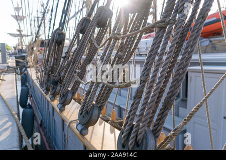 Old vintage pulley system with rigging ropes on a tall ship in a close ...