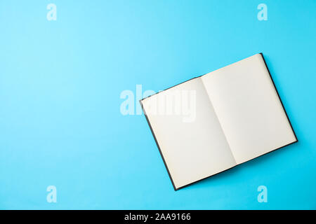 Opened empty book on blue background, space for text Stock Photo