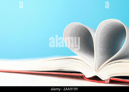 Heart made of pages. Book against blue background, space for text Stock Photo