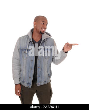 A handsome African American man standing in a jeans jacket, smiling and pointing with his fingers at himself, isolated for white background Stock Photo