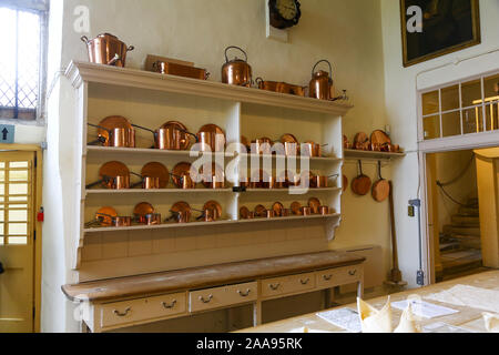 Copper pots and pans on shelves in the kitchen at Hardwick Hall, Derbyshire, England, UK Stock Photo