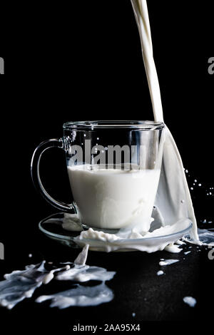 Milk glass and milk splash on black background Stock Photo